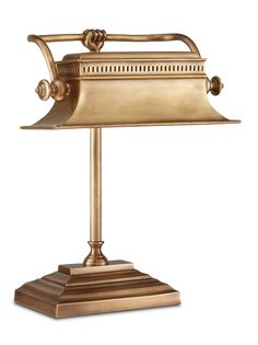 an antique brass desk lamp on a white background