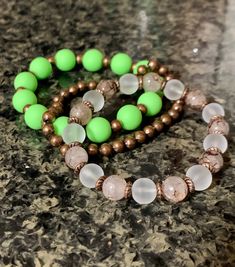 Beautiful trio of bracelets comprised of lime green, translucent white and amber marble beads with copper spacer beads. The largest beads are 10mm. The white and marble beads are 8mm round glass beads. The smaller beads are 5mm iron round beads. The bracelets are approximately 17-17.5 cm in length each. Green And Copper, Bracelet Sets, Beads Bracelet Design, Crystal Healing Stones, Bohemian Bracelets, Photo Bracelet, Bracelet Designs, Healing Stones, Spacer Beads