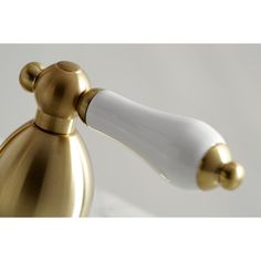 a gold and white bathroom faucet on a white counter with the handle extended