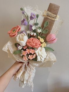 a person holding a bouquet of flowers in their left hand with a burlock on the wall behind them