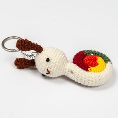 a crocheted keychain shaped like a snail with an apple on it