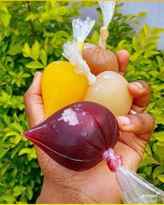 a person holding three different types of fruit in their hands, including an eggplant