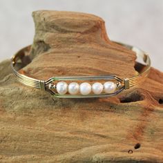 A sweet, eye-catching bracelet of five strands of 14kt gold filled wire with a center design featuring five 4mm genuine freshwater pearls and accented with two smaller 14kt gold filled beads. Perfect to wear every day. Stackable, too, along with many of my other wirewrapped bracelets! The sturdy built-in hook and eye clasp is easy to get on and off by yourself. Pearl is one of the birthstones for June. This would make a most amazing gift for an June birthday girl, or maybe a bride! (Or treat for Adjustable Nickel Free Gold Bracelet, Adjustable Nickel-free Gold Bracelet, Elegant Yellow Gold Nickel-free Bracelets, Handmade Adjustable Yellow Gold Pearl Bracelet, Adjustable Handmade Yellow Gold Pearl Bracelet, Classic Adjustable Nickel-free Jewelry, Wire Wrapped Pearl Bracelet Gift, Delicate Adjustable Hand Wrapped Jewelry, Handmade Adjustable Pearl Bracelet With 14k Gold Filling