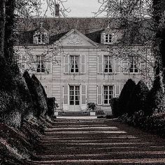 an old house is seen through the trees in black and white photograph, with no people around it