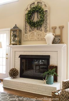 a fireplace with a wreath on top of it and other decorations around the fire place