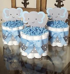 baby shower decorations in blue and gray with elephants on the diaper cake toppers