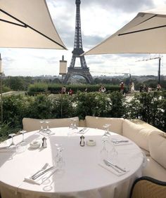 the table is set with place settings for two people in front of the eiffel tower