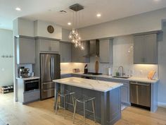 a large kitchen with stainless steel appliances and wooden floors