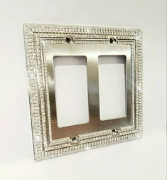 two light switch plates with crystal beading on the sides and one is white in color