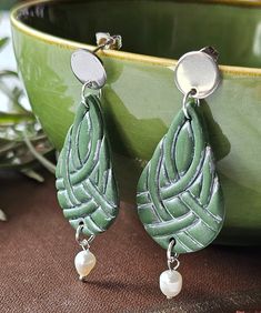 These are unique, handmade, polymer clay earrings with irish knot decoration. These beautiful green earrings are pieces of original and unique artwork. These jewels are very light, the weight of a pair of earrings is 3-4 grams. The earrings are made of polymer clay. The findings are silver-plated stainless steel. I mounted real cultured pearls on the earrings as decoration. Color: moss green, silver Sizes: Earring length: 2.36 inch (60 mm) Width: 0.90 inch (23 mm) You can find the similar EARRIN Handmade Green Clay Jewelry, Handmade Green Clay Earrings, Green Dangle Clay Earrings, Elegant Green Polymer Clay Jewelry, Irish Knot, St Patricks Day Gift, Jewelry Polymer Clay, Clay Dangle Earrings, Green Earrings