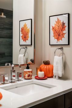 a bathroom with a sink, mirror and pictures on the wall