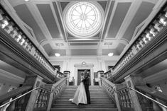 a bride and groom are standing on the stairs