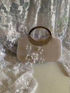 "Beautiful fall bag, amazing details, handmade satin flowers with pearls and crystals. Dimensions: 8\"long x 6.5\" high x 2\" deep NO RETURNS, NO EXCHANGE, PLEASE CONTACT FOR ANY ADDITIONAL QUESTIONS." Rectangular Satin Wedding Bag, Elegant Satin Wedding Bag, Pearl White Evening Bag With Pearl Handle For Wedding, Cream Pearl Evening Bag For Wedding, White Pearl Embellished Evening Bag For Wedding Guest, Wedding Embellished Pearl Evening Bag, Embellished Cream Evening Bag For Wedding, Beige Pearl Embellished Evening Bag For Wedding, White Pearl-embellished Bag For Wedding Guest