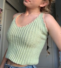 This top is the perfect statement piece for any warm weather outfit, and the vertical ribbing is super flattering! This top took me about two weeks to crochet, and is made out of the sweetest light green cotton yarn. The straps criss cross in the back, and create a cute little keyhole cutout. The green is outlined with a light pink trim, which makes this top even more spring-y :) Green Knitted Cotton Tops, Green Cotton Knitted Tops, Green Ribbed Cotton Tank Top, Green Ribbed Knit Top For Spring, Fitted Green Crochet Top For Spring, Casual Green Crochet Knit Top, Trendy Green Crochet Top For Spring, Casual Green Crochet Top, Green Fitted Knit Crochet Top