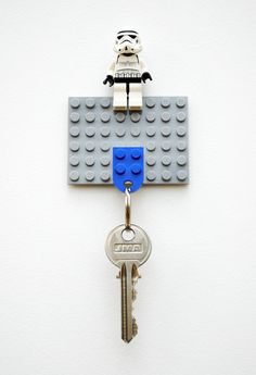 a lego keychain is hanging on the wall with a bunch of keys attached to it