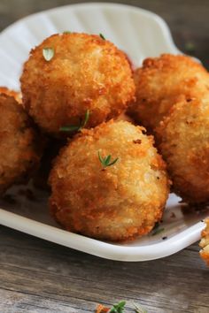 some fried food on a white plate with parsley sprinkled around it's edges