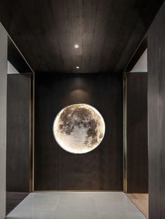 an empty room with black walls and a large moon on the wall in the center