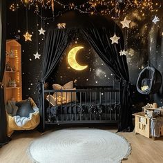 a baby's room with stars and moon decorations on the walls, black drapes, and a crib