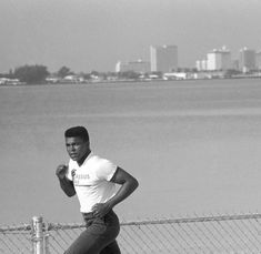 a man is running on the sidewalk near water and buildings with an instagram post about him