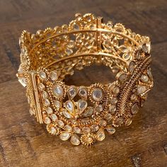 Vintage Traditional Indian Gold Toned Cuff Bracelet with Glass Crystals and Floral Motifs Secure Closing Beautiful vintage gold toned cuff bangle bracelet with screw secure closing. Floral motifs with embedded crystals. Great vintage condition.Measurements Width: 3.5cm/1.4”Diameter: 6cm/2.4” Shell Ring, Vintage Traditional, Cuff Bangle Bracelet, Carved Shell, Trade Beads, Beaded Tassels, Traditional Indian, Cuff Bangles, Floral Motifs