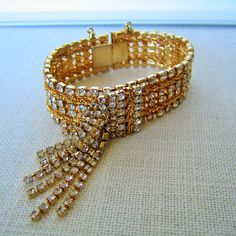 "Featured here is a wonderful, glitzy vintage designer cha-cha rhinestone bracelet from Hobe'.  Measuring 7\" long and 3/4\" wide, it is in excellent condition, looking new with all prong-set stones intact. It features round, clear rhinestones with gold tone roped accents, utilizing a dangling cha-cha aspect. It is marked \"Hobe' \" on the clasp. This collectible piece is another example of the fine quality associated with the Hobe' Company. Hobe' pieces are highly sought after by collectors. Th Designer Wedding Jewelry, Jewelry Bridal, Bridal Gift, Bracelet Vintage, Designer Wedding, Rhinestone Bracelet, Jewelry Companies, Vintage Designer, Vintage Costume Jewelry