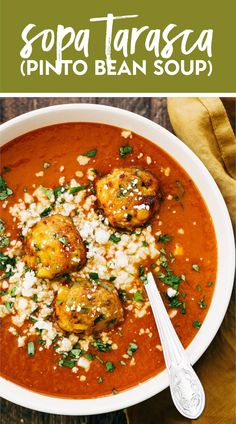 a white bowl filled with soup next to a spoon