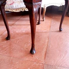 an old wooden table sitting on top of a tile floor