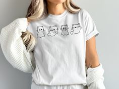 🐱👻 Embrace the spooky season with our Cute Ghost Cats T-Shirt! Featuring an adorable lineup of ghostly cats, this kawaii graphic shirt is perfect for Halloween and cat lovers alike. Whether you're trick-or-treating or attending a Halloween party, this stylish and fun tee will surely catch everyone's eye. Great as a gift for cat enthusiasts or anyone who loves a touch of cuteness in their spooky attire. Get ready to be haunted by cuteness! 🕸️🎃 Available in the following products: SWEATSHIRT ( White Cat Print T-shirt For Halloween, Spooky Cat Print Crew Neck T-shirt, Halloween White T-shirt With Cat Print, Spooky Cotton Tops With Cat Design, Spooky Cotton Top With Cat Design, Spooky Cat, Chat Halloween, Ghost Cat, Cat Lover Gift