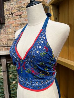 This vibrant, hand-embroidered bikini halter top offers stylish Boho-inspired fashion with its colorful threads and sequin embellishments. Paired with jeans or a skirt, this is the perfect summer top to stand out in and make a statement. The lining is a contrasting color to give it a unique, eye-catching look. One Size Made in India Care Instructions: Dry clean only Girl In The Mirror, Colorful Threads, Fashion Vibes, Inspired Fashion, The Mirror, Summer Top, Perfect Summer, Halter Top, Contrasting Colors