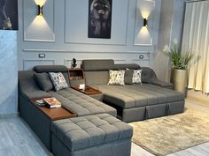 a living room with grey couches and coffee table in front of a painting on the wall