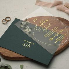 a wooden cutting board with a wedding card on it and some scissors next to it