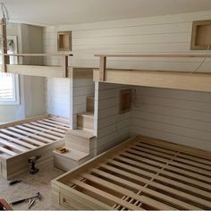 a loft bed is built into the side of a wall in a room with white walls and wood flooring