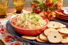 a bowl of coleslaw and crackers on a plate with flowers in the background