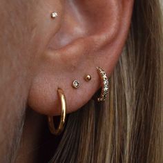 a woman wearing three different types of ear piercings on her left side of the ear