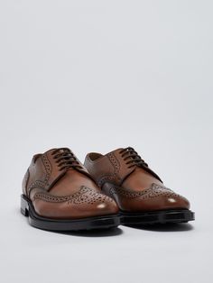 Upper: 100% Calf leather Sole: 100% Rubber Luxury Cognac Oxfords With Brogue Detailing, Luxury Cognac Leather Shoes With Brogue Detailing, Luxury Brown Almond Toe Derby Shoes, Luxury Brown Almond Toe Derby, Luxury Brown Derby Shoes With Brogue Detailing, Luxury Brown Derby With Brogue Detailing, Timeless Brown Lace-up Shoes With Rubber Sole, Luxury Cognac Dress Shoes With Brogue Detailing, Luxury Wingtip Leather Shoes With Goodyear Welt