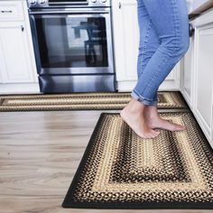 a woman is standing on the kitchen floor with her feet in the oven door mat