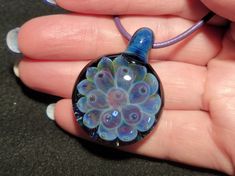 Indulge in the beauty of handcrafted art with these stunning implosion pendants! Each blown glass pendant is meticulously crafted by me, using only the finest quality Borosilicate glass and a blowtorch in my studio. I take great pride in the intricate designs and depth of each glass flower choker, which remind me of the delicate lotus blossoms, succulents or anemones, carefully captured in glass. As a one-of-a-kind creation, each pendant is truly unique and crafted entirely from molten glass.  The hand blown glass pendant has a large glass bail  which also provides flexibility to change the chains and cords for a different look. The pendant comes with a leather cord with a sterling silver lobster claw clasp. I custom-make each leather cord to order and can accommodate different lengths as Unique Handmade Clear Jewelry, Handmade Clear Round Pendant Jewelry, Handmade Glass Flower Pendant Necklaces, Handmade Glass Flower Necklace, Handmade Iridescent Necklace With Round Pendant, Handmade Clear Flower Pendant Jewelry, Handmade Czech Glass Round Pendant Jewelry, Unique Iridescent Round Pendant Jewelry, Handmade Clear Jewelry With Flower Pendant