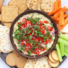 a platter filled with crackers and vegetables