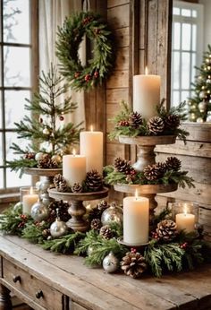 christmas decorations with candles and pine cones on a table