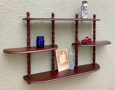 two wooden shelves with pictures and vases on them