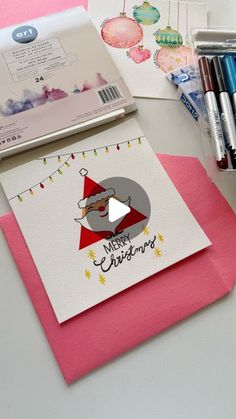 a christmas card with a santa clause on it and some crayons next to it