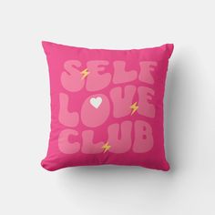 a pink pillow with the words self love club printed on it and a lightning bolt