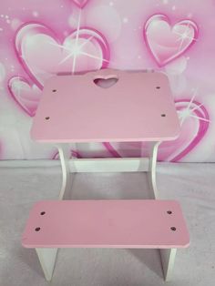 a pink table and bench with hearts painted on it