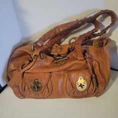 "Vintage Frye Heavy Leather Satchel Handbag With Rivets & Toggle Closure. Bag would benefit from an overall cleaning inside and out. There is a bit of discoloration on the handles which might be improved with cleaning. The lining has a couple of small dark spots, a couple of pink spots, and is a bit soiled from years of use. There are no holes or tears in the lining. The outside leather has a few discolored spots and a couple of whitish spots. Photos are an important part of the description. Mea Vintage Leather Bags With Hardware Details, Vintage Satchel With Branded Hardware For Daily Use, Vintage Leather Bags With Hardware, Leather Tote Shoulder Bag With Hardware, Brown Leather Bags With Hardware, Everyday Vintage Shoulder Bag With Branded Hardware, Virgo Rising, Michael Thompson, Fashion Goals