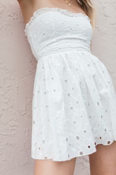 Our Lainey Eyelet Mini Dress has a strapless, sweetheart design with delicate ruffle detailing and a zipper closure. True to Size 100% Cotton Ruffle Neckline Lined Hand Wash, Hang Dry Patriotic Tees, Strapless Tops, Tres Chic, Swimsuit Tops, White Mini Dress, Denim Shop, Denim Dress, Short Sleeves Tops, Jumpsuit Romper