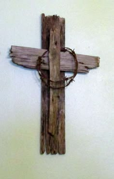 a cross made out of wood with barbed wire on the bottom and one piece of wood attached to it