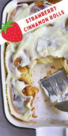 a strawberry cinnamon roll in a pan with a spatula and strawberries on top