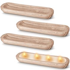 three wooden trays with lit candles on the sides and one in the middle, set against a white background