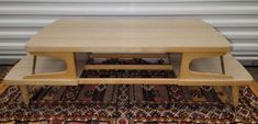 a wooden table sitting on top of a rug