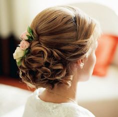 a woman with flowers in her hair is looking off to the side while wearing a white dress